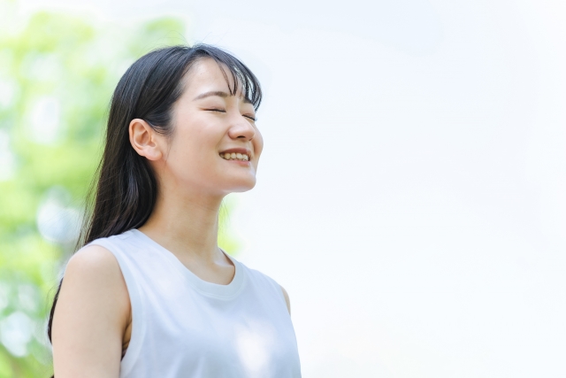 グラウンディング呼吸法 自然の中で深呼吸する女性